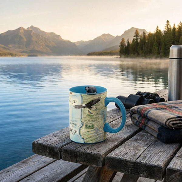 Flathead Lake Mug with nature design on a wooden dock by a lake with mountains in the background