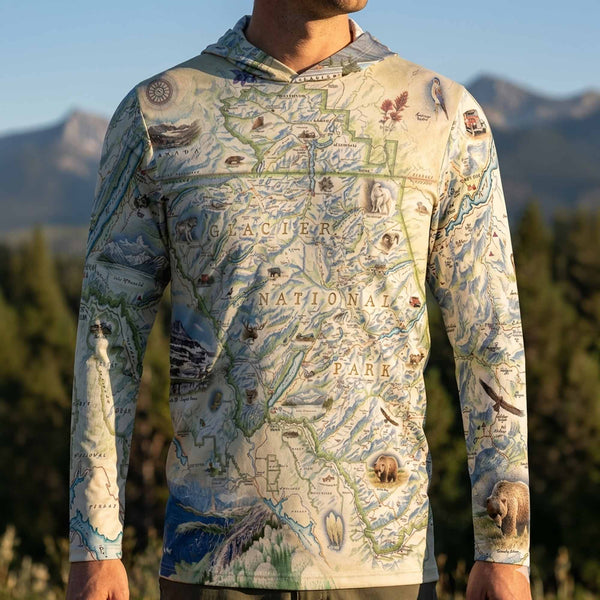 Person wearing a map-themed sun shirt hoodie with mountains and nature designs in the background
