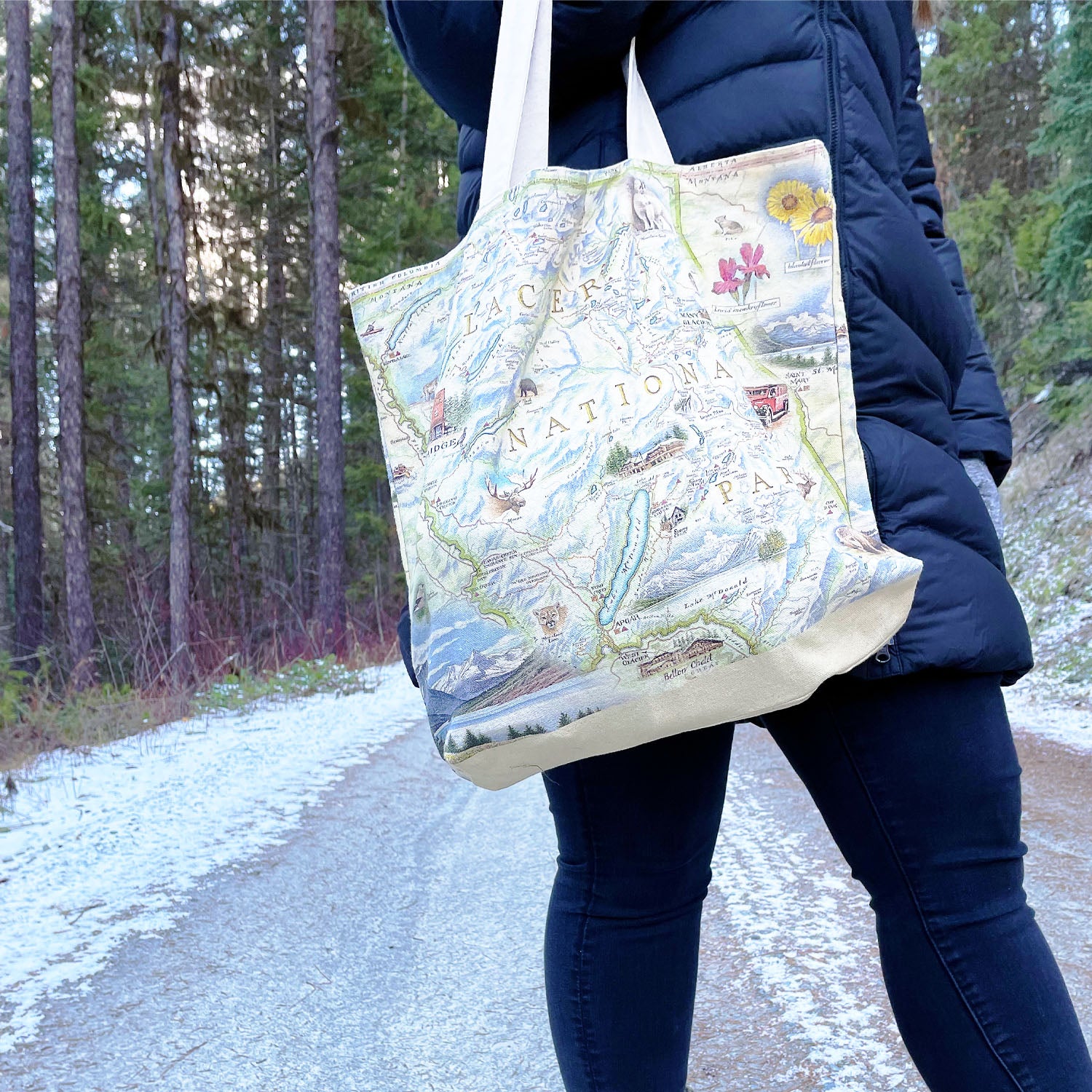 Women carrying a Glacier National Park Tote Bag by Xplorer Maps. The women is on a trail in a forest in Montana. 
