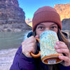 Women  drinking out of a Canyon National Park Map Coffee Mug in front of Grand Canyon and Colorado River. 