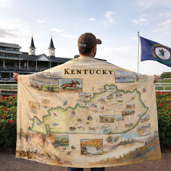 Person holding a Kentucky-themed blanket with a race track in the background