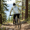 Person wearing a Tahoe sun shirt hoodie riding a bike on a trail with a scenic Lake Tahoe background
