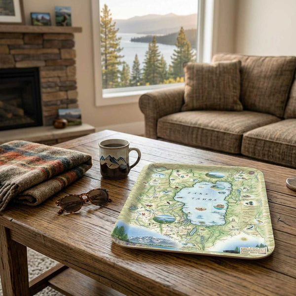 Living room with a wooden coffee table featuring a scenic Lake Tahoe map tray, mug, and sunglasses.