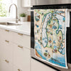 Michigan State Map Kitchen Dishwashing Towel hanging on the kitchen stove handle. The Map features the Great Lakes, Detroit, Ann Arbor, Grand Rapids, and Lansing in earth tones of blue and greens. The tea towel also features  Nature, animals, ducks, deer, fish, moose lighthouses, wolverines, and the Mackinac Bridge.