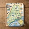 Map of Maine on a decorative tray with a glass of lemonade on a wooden surface