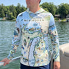 Person wearing a sun shirt hoodie with a map of Michigan design, standing on a boat by a lake.