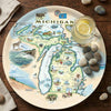 Serving Tray Map of Michigan on a decorative plate with a glass of lemonade and stones on a wooden surface.