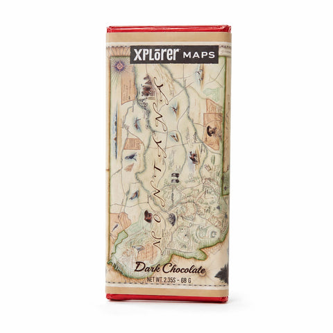 A single wrapped chocolate bar standing upright on a white background. The wrapper features a vintage map design labeled 'Xplorer Maps' and 'Magna Carta', with 'Dark Chocolate' written near the bottom.