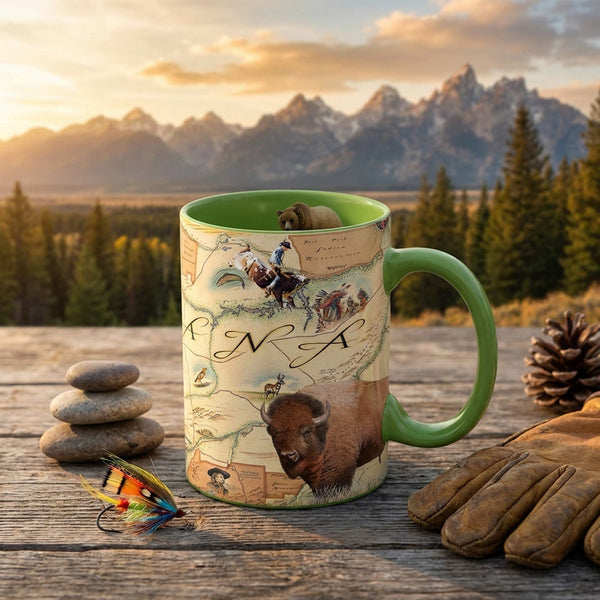 Green mug with nature-themed design on a wooden surface with mountains in the background