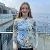 Person wearing a sun hoodie with Monterey Bay design by the ocean.