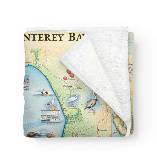 Monterey map blanket folded to show soft Berber fleece lining. Made of 50% Berber fleece and 50% microfiber fleece with a hand-drawn map design.