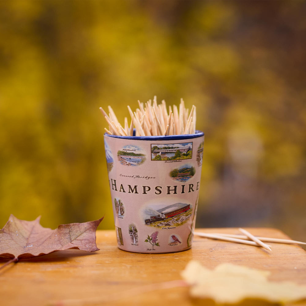 Shot glass of toothpicks with Hampshire design on a wooden surface with autumn leaves.