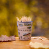 Shot glass of toothpicks with Hampshire design on a wooden surface with autumn leaves.