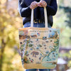 Tote bag with a map of North Carolina held by a person outdoors.