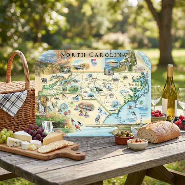 Picnic setup with a North Carolina map serving tray on a wooden table outdoors.