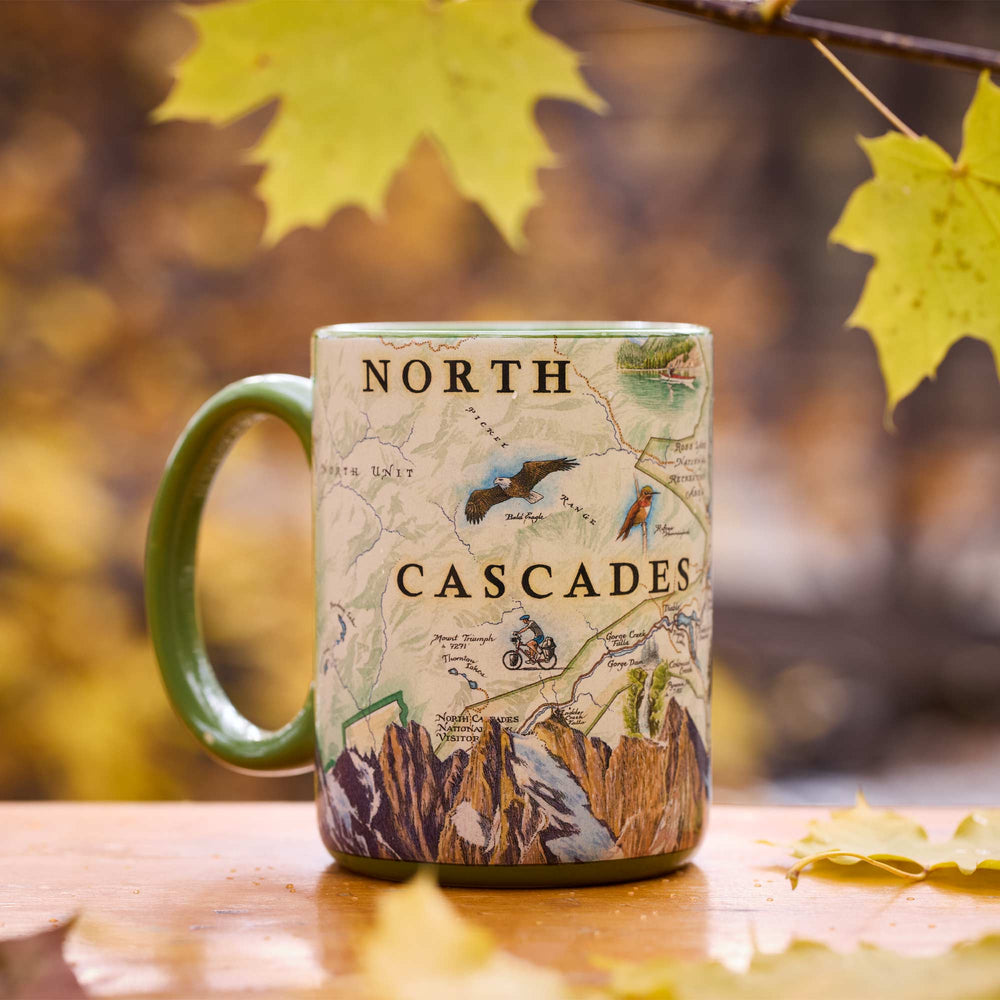 North Cascades National Park Map Ceramic Mug – 16 oz with fall leaves in background