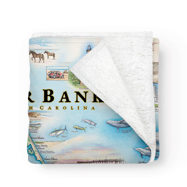 Folded Blanket: Wrap yourself in the coastal allure of the Outer Banks with this cozy fleece blanket. Featuring serene beach scenes, iconic lighthouses, and vibrant marine life, it's the perfect way to stay warm and cozy while reminiscing about your favorite North Carolina destination.