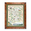 Hand-drawn map of Rocky Mountain National Park in a pine frame with green mat, showcasing earth tones of green and beige. Illustrations feature landmarks such as Trail Ridge Road, Mount Ganby, Estes Park, and Alpine Visitor Center, alongside flora and fauna like bobcat, snowshoe hare, Indian paintbrush, and wild rose. Dimensions: 18x24 inches.