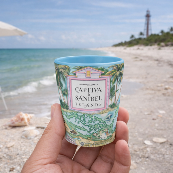 Hand holding a 'Captiva & Sanibel Islands' themed cup on a beach with a lighthouse in the background.