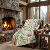 Cozy living room with a stone fireplace, leather chair, and scenic blanket.