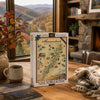 A 1000-piece jigsaw puzzle box titled 'Shenandoah National Park' stands on a wooden table in a cozy living room setting with a window showing autumn mountains, a mug, and a blanket nearby.