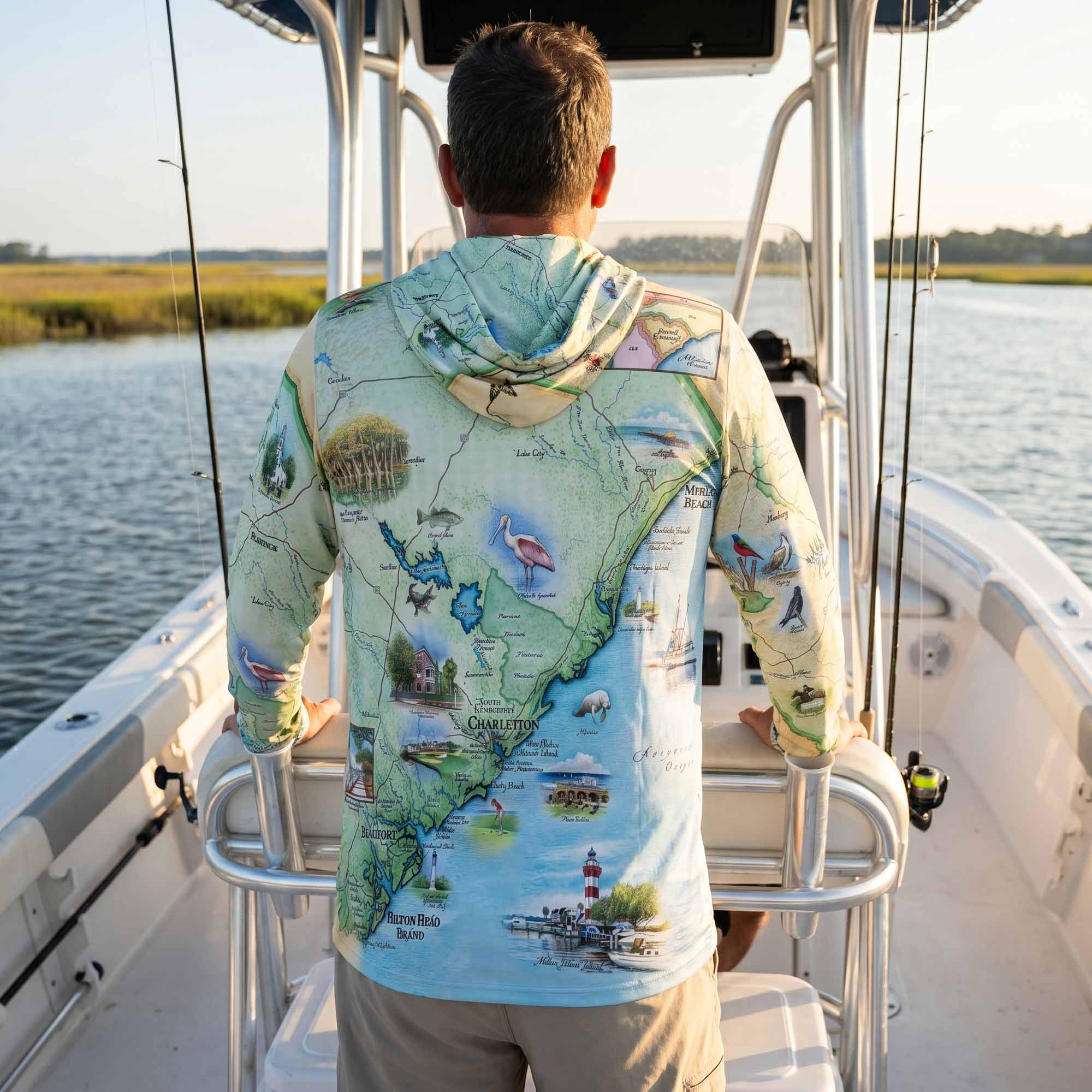 Person wearing a map-themed hoodie on a boat by a body of water