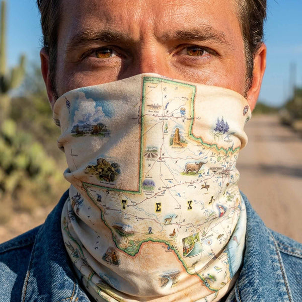 Person wearing a Texas-themed face cover with a desert landscape in the background