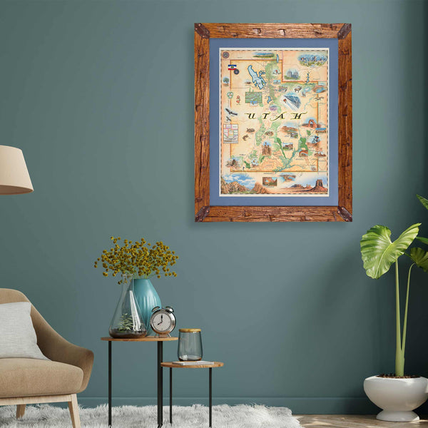 Framed Utah State Map hanging on a greenish teal wall above a plant and chair in a living room. 