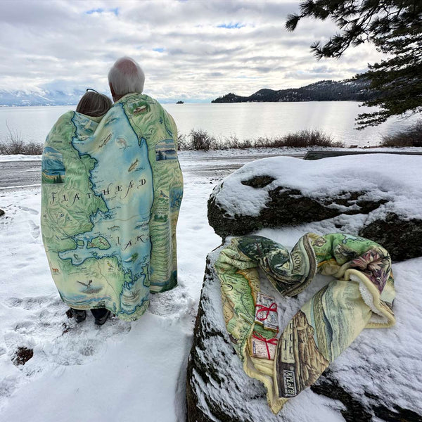 Two people wrapped in a blanket on Flathead Lake. 