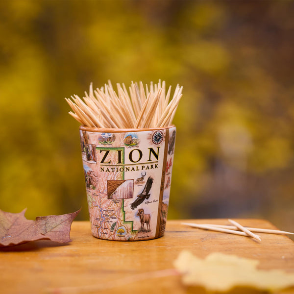 Shot glass of toothpicks with Zion National Park design on a wooden surface with blurred natural background
