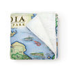 Folded Acadia National Park Map Fleece Blanket in earth tones. Features historical sites such as: Cadillac Mountain, Jordan Pond Gatehouse, Park Loop Road, Sand Beach, Otter Cliff, and Thunder Hole. Flora and fauna Harbor Seal, Humpback and Finback Whales, the Common Loon, White-tailed Deer, Red Fox and Goldenrod and Blue Aster wildflowers. 
