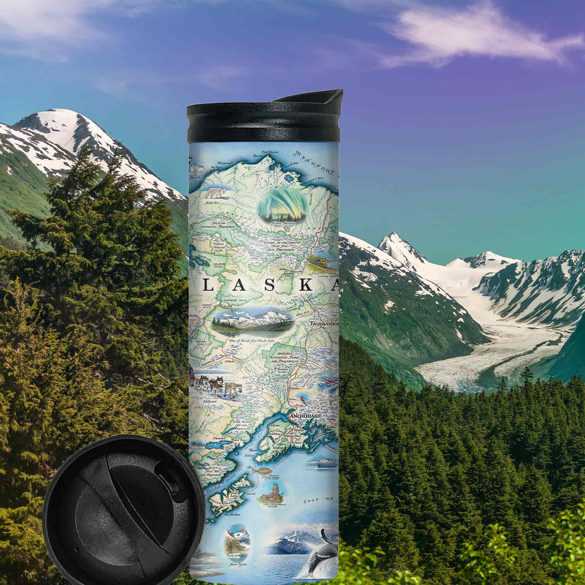Alaska State Map 16 oz Travel Drinkware in earth tone colors sitting on rocks by water during sunset or sunrise.