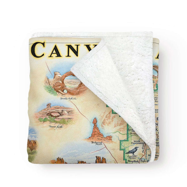Arches & Canyonlands National Park Fleece Blanket in earth tones. It features Island in the Sky, Panorama Point Overlook, Angel Arch, Chester Park, Pete’s Mesa, Colorado and Green River, Park Avenue, Double Arch, Balanced Rock, Tower Arch, Double O Arch, and Delicate Arch.  Wildlife and plants include rattlesnakes, bobcats, Desert Bighorn sheep, falcons, golden eagles, red foxes, porcupines, mule deer, mountain lions, coyotes, and lizards. Indian Paintbrush, Claret Cup Cacti, and Columbines. 