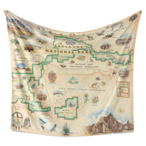 Hanging Badlands National Park Map fleece blanket in earth-tone colors. Featuring Vulture Peak, Red Shirt Table Overlook, Yellow Mounds, and Cedar Pass. A wide array of plants and animals such as bison, elk, bighorn sheep, owls, frogs, snapping turtles, pronghorn antelope, bobcats, mountain bluebirds, meadowlarks, coyotes, foxes, badgers, ferrets, prairie rattlesnakes, bald eagles, golden eagles, and turkey vultures. 