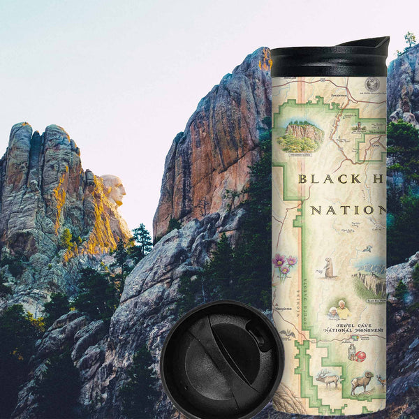 Black Hills National Forest Map Travel Thermos. In the background is Mount Rushmore with President George Washington. The map Features cities like Rapid City, Spearhead, Rapid City, and Sturgis. Mount Rushmore, Devils Tower, Jewel Cave National Monument, Custards, and Wind Cave National Park. Flora and Fauna illustrations include bison, elk, mountain goats, birds, pine trees, and native flowers. 