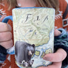 Women holding a blue 16 oz ceramic coffee mug of Flathead Lake, Montana. The cup has black bear and cubs on it. 