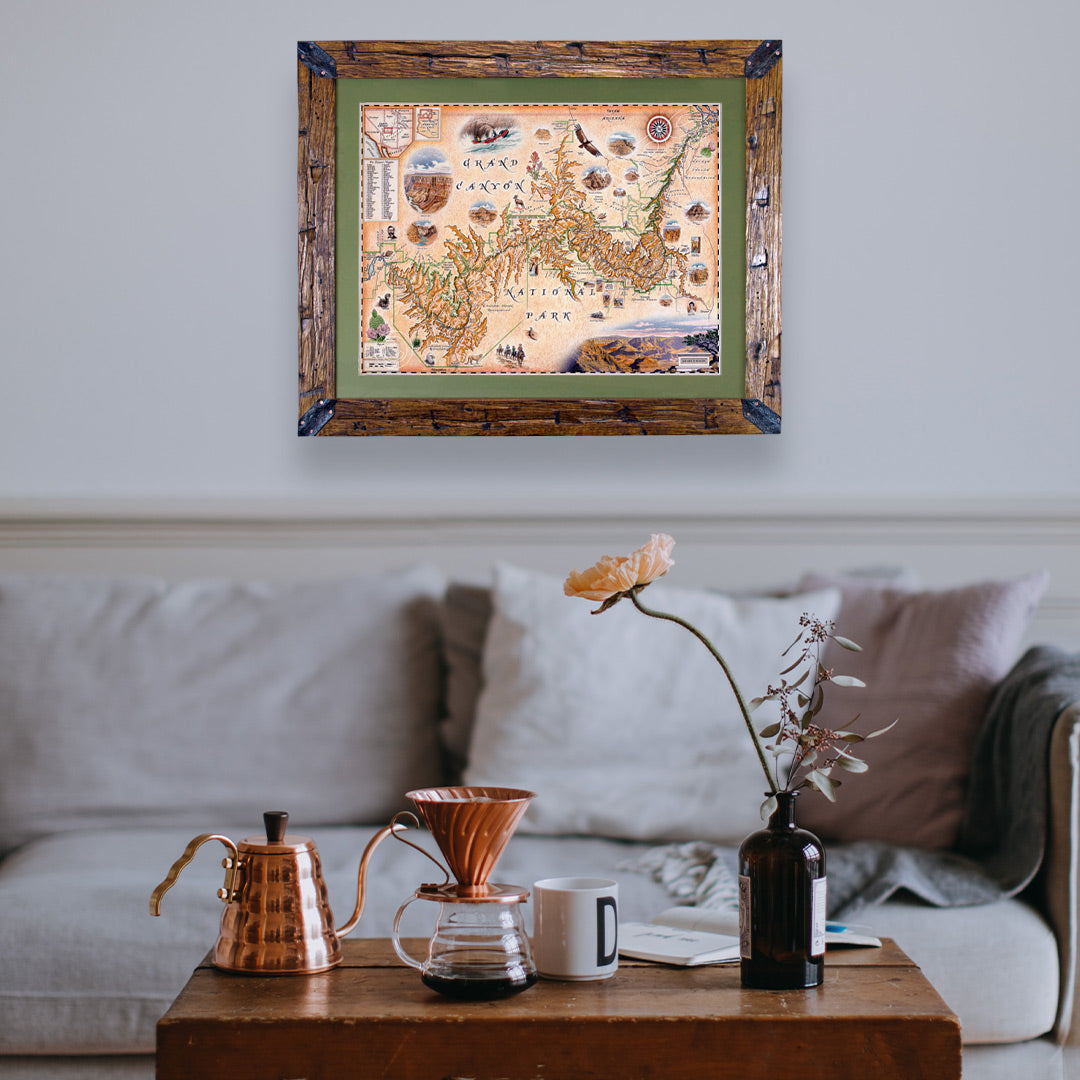 Grand Canyon National Park Framed Map hanging above a gray couch. The map is framed in hand-scraped Montana Pine.