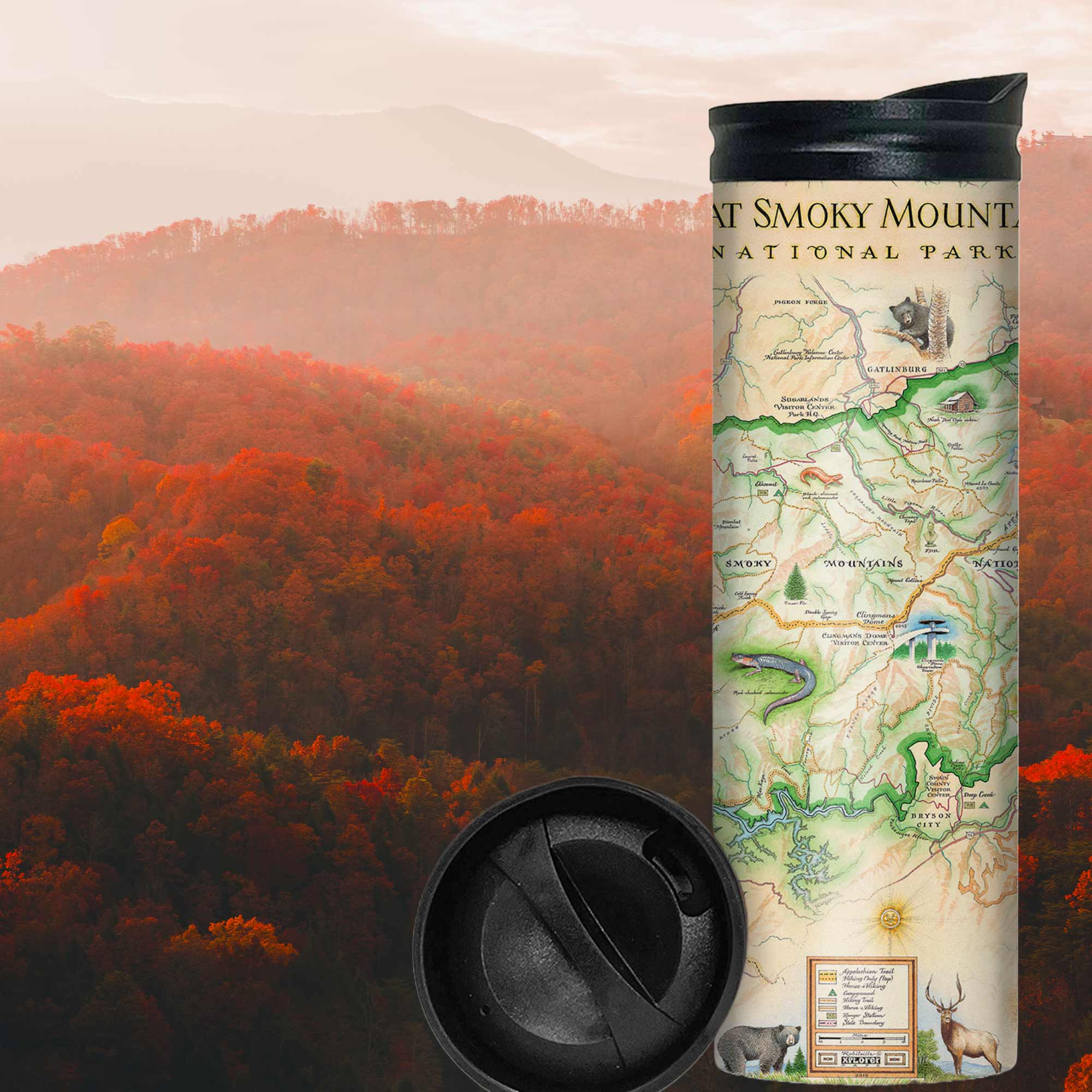 Great Smoky Mountains National Park Map travel drinkware with colorful red, orange, and green leaves on trees during sunset.  The map depicts the entire National Park on the border of North Carolina and Tennessee. It features illustrations of a salamander, woodpecker, Clingman's Dome, Sugarland's Visitor Center, and Oconoluftee Visitor Center. 