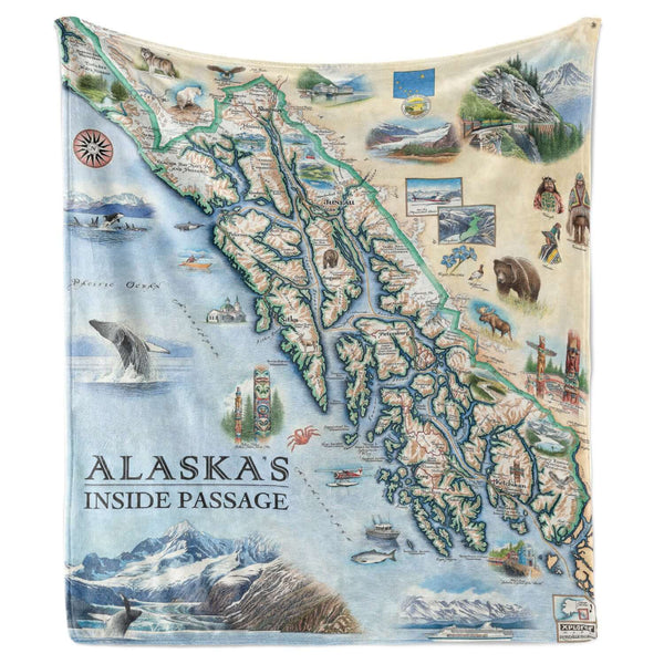 Hanging fleece blanket featuring a map of Alaska's Inside Passage. The map features totem poles of native peoples, bears, whales, fish, mountain goats & sheep. Flora is an illustration of forget-me-nots. Including the towns of Sitka, Juneau, Ketchikan, and others.