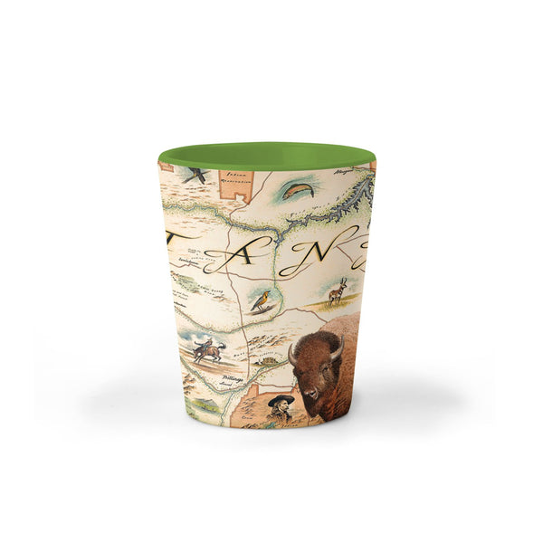 Green Montana State Map Ceramic shot glass by Xplorer Maps. The map is featuring Sacajawea, Lewis & Clark, Yellowstone, Glacier National Park, Flathead Lake, grizzly bear, bald eagle, and elk. Cities like Missoula, Bozeman, Helena, and Whitefish are included in the print. 