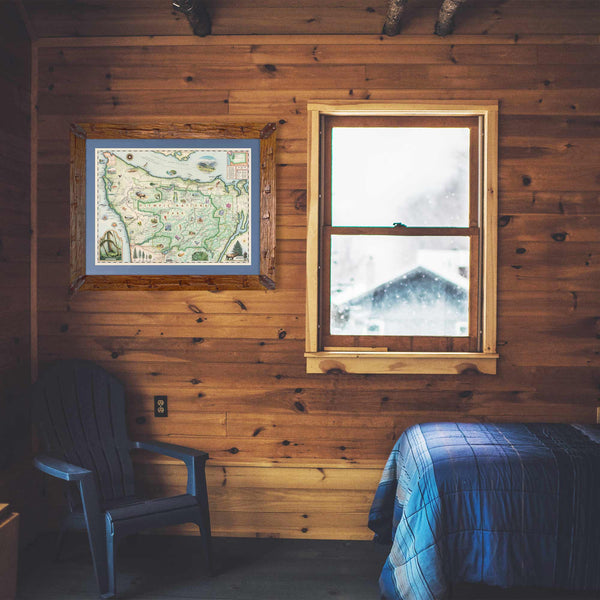 Olympic National Park Map in a Montana Pine frame with blue mat hanging in a log cabin bedroom with blue bedspread. 