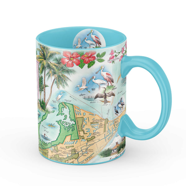 Blue 16 oz Sanibel & Captiva Islands Map Ceramic Mug. The map features illustrations of places such as Ding Darling Wildlife Sanctuary, Bailey-Matthews Shell Museum, and Sanibel Lighthouse. Flora and fauna include the Loggerhead sea turtle, Manatee, and Great Blue Heron. Many other birds and sea animals are illustrated.